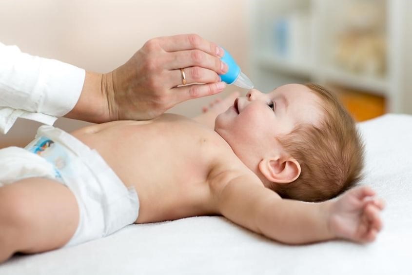Cha mẹ vệ sinh mũi cho trẻ bằng dung dịch nước muối sinh lý